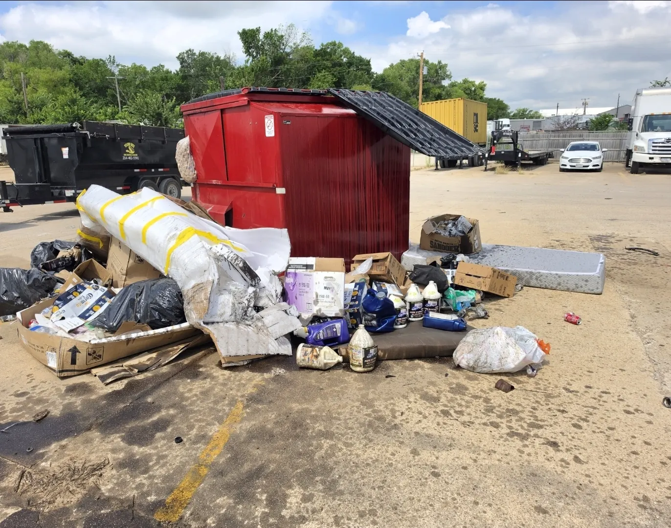 Overflowing dumpster area before cleanup