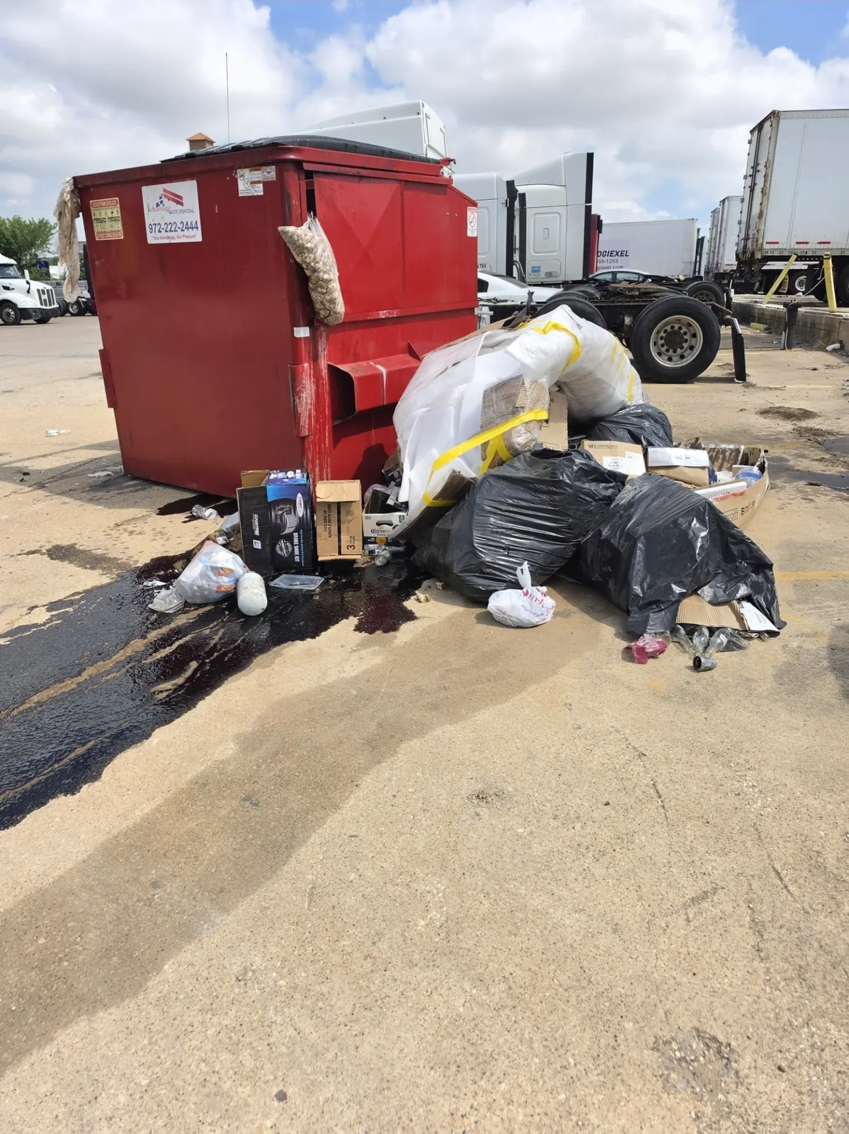 Junk piled around commercial dumpster