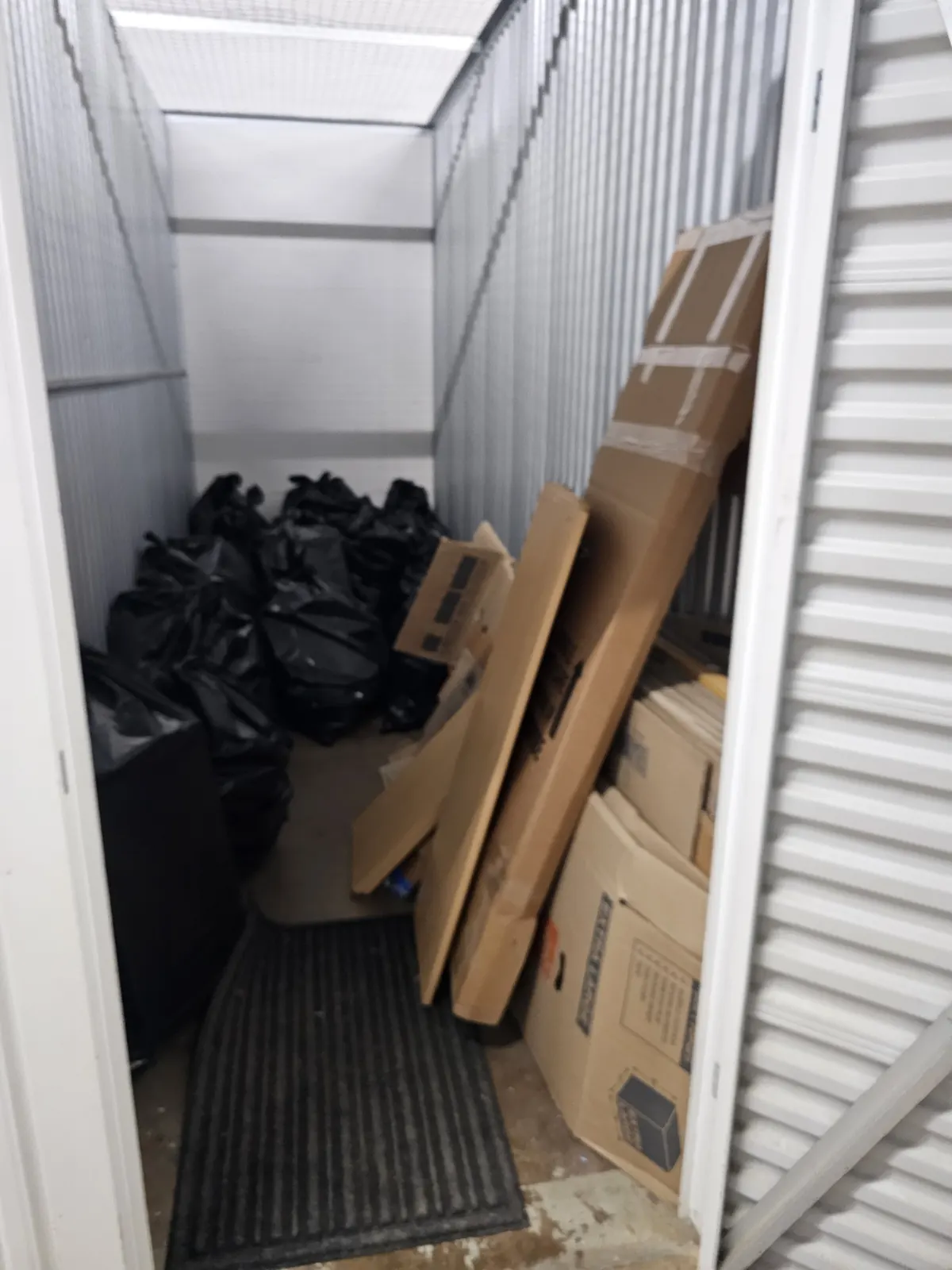 Storage unit full of bags and boxes before cleanout